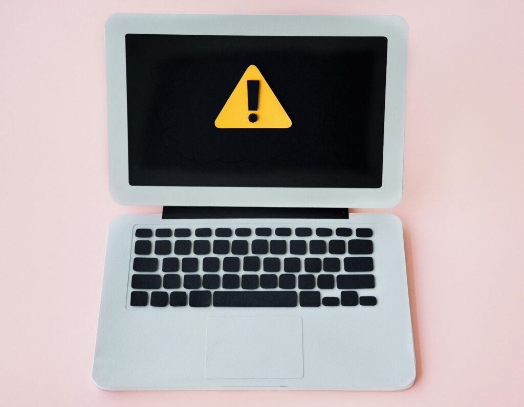 Grafika laptopa ze znakiem ostrzegawczym (wykrzyknik na żółtym tle) na ekranie. 